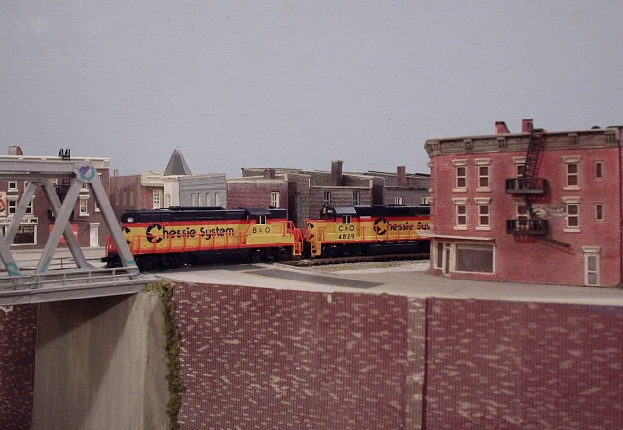 Atlas N-scale GP9 diesel locomotives beside a bridge on a layout