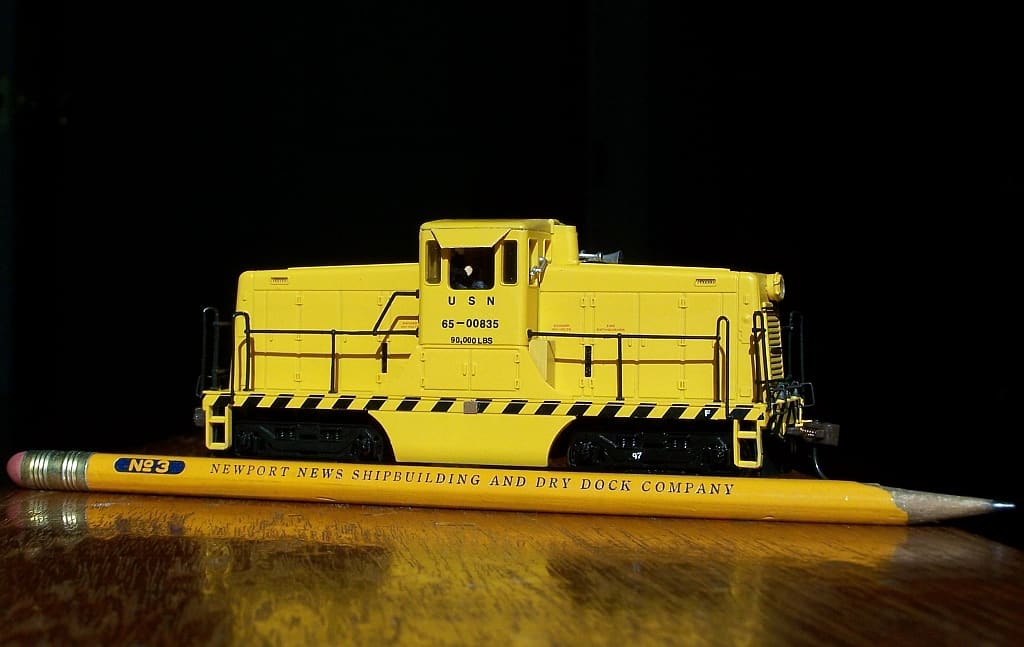 Bachmann HO yellow 44-ton switcher with a pencil beside it for scale