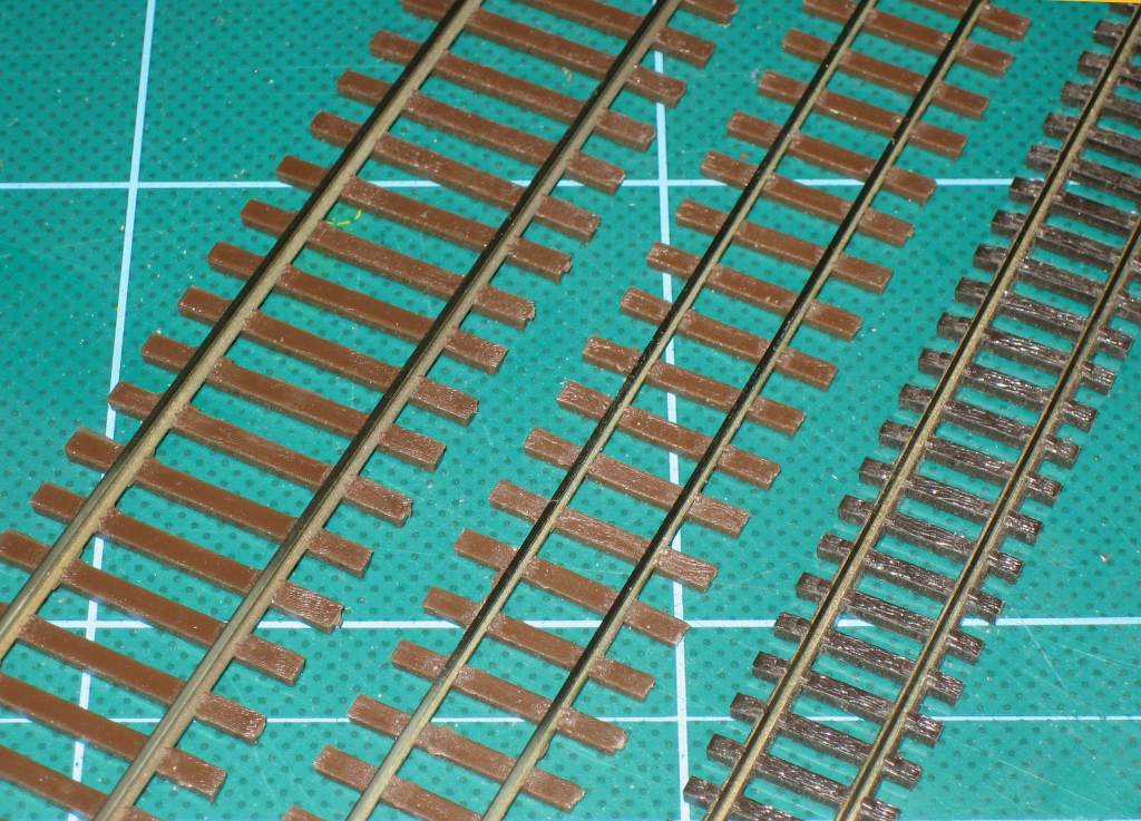 Three pieces of model track side by side: the left is widest; the middle is narrow with large sleepers; the right is narrow with small sleepers